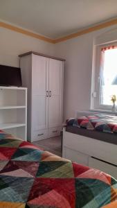 a bedroom with two beds and a cabinet and a window at FeWo LoBec 2 in Calau