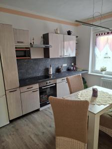 a kitchen with a table with chairs and a dining room at FeWo LoBec 2 in Calau