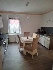 a kitchen with a table and chairs in a room at FeWo LoBec 2 in Calau