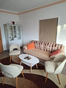 a living room with a couch and chairs and a table at FeWo LoBec 2 in Calau +6 photos