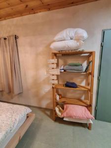 a room with a bed and a shelf with pillows at שיר ערש in Giv'at Yo'av