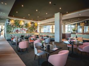 a restaurant with tables and chairs and a mural at Van der Valk Hotel Amsterdam Zuidas-Rai in Amsterdam