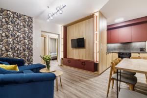 a living room with a blue couch and a table at Apartamenty Polna 60 in Żory