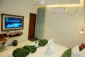 a living room with a couch and a tv at MR Suites Dharwad in Dhārwād