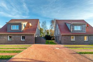 a house with two windows and a brick driveway at Ferienwohnung Ebbe in Tannenhausen