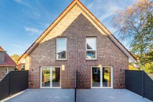 a brick house with a triangular roof at Ferienwohnung Ebbe in Tannenhausen