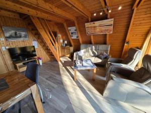 a living room with couches and a tv in a cabin at Haus Stern Carolinensiel in Carolinensiel