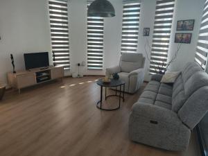 a living room with a couch and a chair and a tv at Anamor apartment 408 in Larnaca