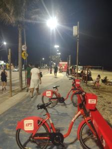 two red bikes parked on a beach at night at Casa com 03 Quartos, Piscina e Churrasqueira em Itaipuaçu Maricá RJ in Maricá