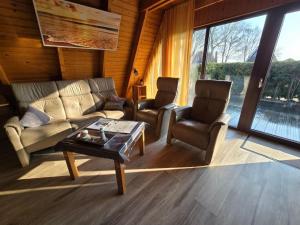 a living room with a couch and two chairs and a table at Haus Stern Carolinensiel in Carolinensiel +13 photos