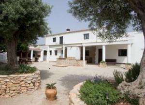 a large white house with a patio and trees at La iaia Merce in L'Aldea