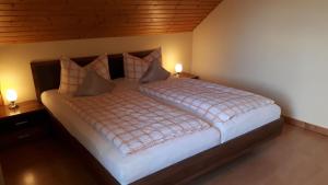 a large bed in a bedroom with two lights on at Fewo Perle Medebach in Medebach