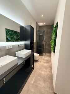 a bathroom with two sinks and a shower and a toilet at Elcami Living in Fritzens +22 photos