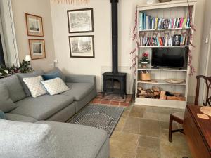 a living room with a couch and a fire place at The Stables in Corsley +10 photos