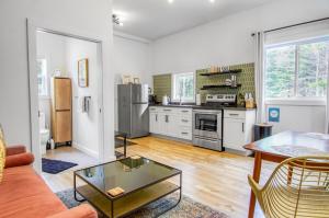 a living room with a table and a kitchen at Flora Studio on the Lake in Saint Martins