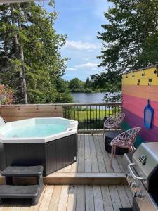 a hot tub on a deck next to a lake at Flora Studio on the Lake in Saint Martins +10 photos