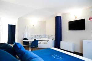 a room with a bed and a tv and a table at Rooms Vesuvio Est in Striano