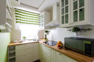 a kitchen with white cabinets and a microwave at EUROPA22 "TU i TERAZ" Apartament Przytulny CENTRUM MIASTA Tomaszów Maz PARKING gratis EXPRESOWE zameldowanie od 13 in Tomaszów Mazowiecki