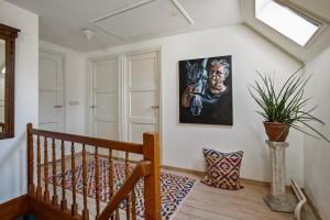 a room with a staircase with a painting on the wall at boerderij, voorhuis in Schimmert