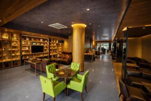 a lobby with green chairs and a table in a building at The Mirah Hotel Bogor in Bogor
