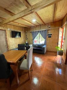 a dining room with a table and a couch at Cabañas Maite Panguipulli Calafquen 2 in Huellahue