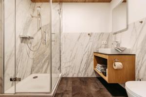 a bathroom with a shower and a toilet and a sink at Schöne Aussicht in Riezlern