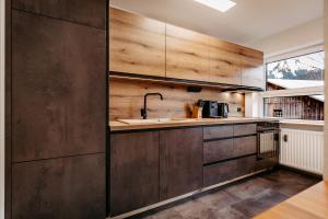 a kitchen with wooden cabinets and a sink at Schöne Aussicht in Riezlern +19 photos