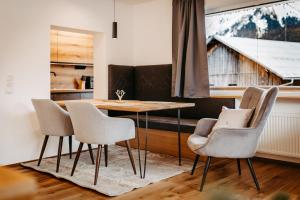 a dining room with a table and chairs and a window at Schöne Aussicht in Riezlern