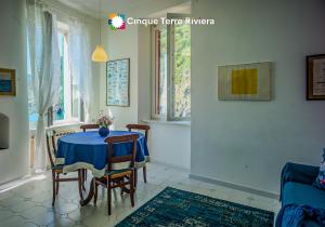 a dining room with a blue table and chairs at Maemuna Sea View Apartment in Vernazza