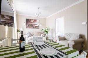 a living room with a table with a bottle of wine at EUROPA22 "TU i TERAZ" Apartament Przytulny CENTRUM MIASTA Tomaszów Maz PARKING gratis EXPRESOWE zameldowanie od 13 in Tomaszów Mazowiecki