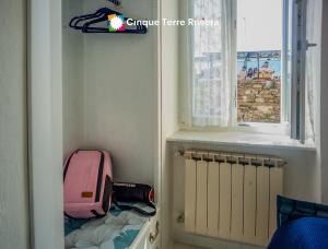 a small room with a suitcase and a window at Maemuna Sea View Apartment in Vernazza +22 photos