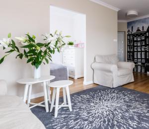 a living room with a table and a chair at EUROPA22 "TU i TERAZ" Apartament Przytulny CENTRUM MIASTA Tomaszów Maz PARKING gratis EXPRESOWE zameldowanie od 13 in Tomaszów Mazowiecki