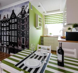 a dining room with a table with a bottle of wine at EUROPA22 "TU i TERAZ" Apartament Przytulny CENTRUM MIASTA Tomaszów Maz PARKING gratis EXPRESOWE zameldowanie od 13 in Tomaszów Mazowiecki