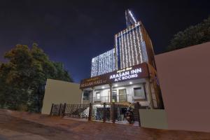 a tall building with lights on top of a building at Capital O Jayam Residency in Chennai