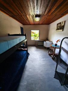 a room with a bed and a table in it at Chalé no Plantar em Casa in São Roque