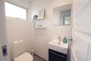 a white bathroom with a toilet and a sink at Granlunden id089 in Esbjerg