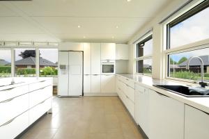 a kitchen with white cabinets and windows at Granlunden id089 in Esbjerg +6 photos