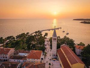 a sunset over a town with a church and the ocean at Casa Rinata in Novigrad Istria