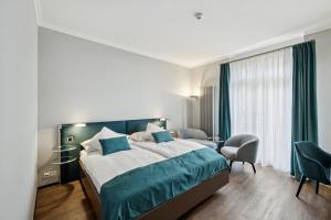 a hotel room with a large bed and a chair at GLANDON Rooms Elite in Biel