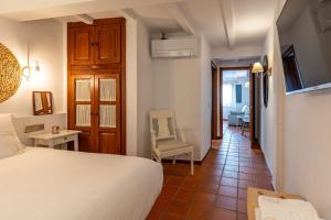a bedroom with a bed and a chair in a room at Natural&Mente Apartamentos Valle del Jerte in El Torno