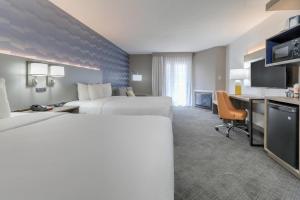 a hotel room with two beds and a desk at Comfort Inn & Suites at Dollywood Lane in Pigeon Forge