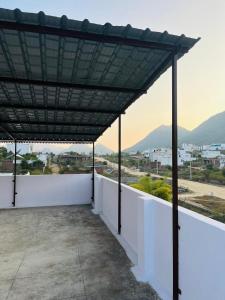 awning over a white wall with a view of a city at Kozy Cottage udaipur in Udaipur