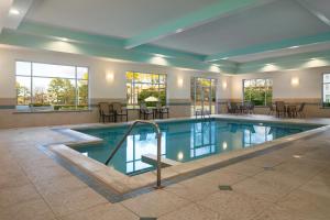 a pool in a hotel with tables and chairs at DoubleTree by Hilton Norfolk Airport in Norfolk
