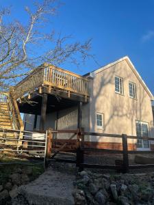 a house with a deck on the side of it at West Coast Whistlestop in Ochiltree
