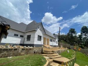 a large white house with a yard and stairs at Meru Nest Arusha in Arusha