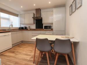 a kitchen with a table and two chairs at Seaside Serenity in Lytham St Annes