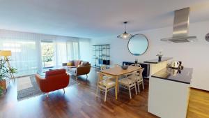 a kitchen and living room with a table and chairs at Relax and Recharge By The Lake! Modern Morges Apartments, AP26 in Morges