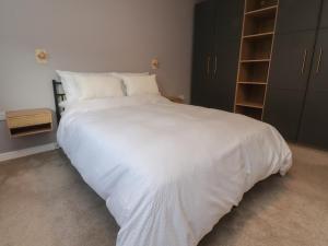 a bedroom with a large bed with white sheets at Seaside Serenity in Lytham St Annes
