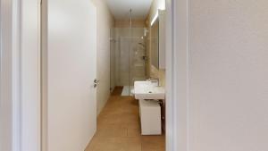 a white bathroom with a sink and a mirror at Relax and Recharge By The Lake! Modern Morges Apartments, AP26 in Morges +71 photos