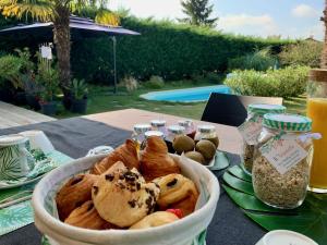 a table with a basket of pastries on it at Les Tignoliers in Tignieu-Jameyzieu +34 photos